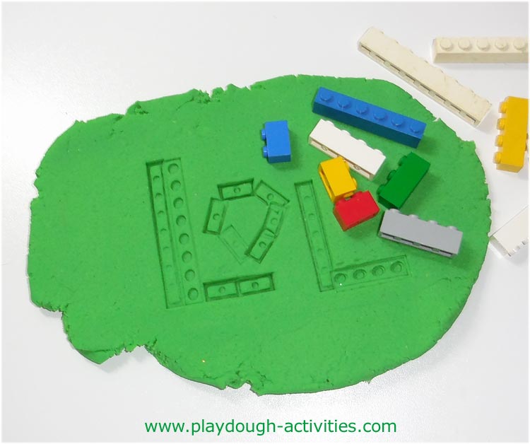 Making letters in the surface of playdough using lego bricks