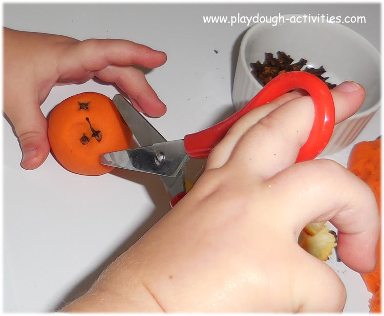 Cutting playdough with scissors to support children's fine motor skills development