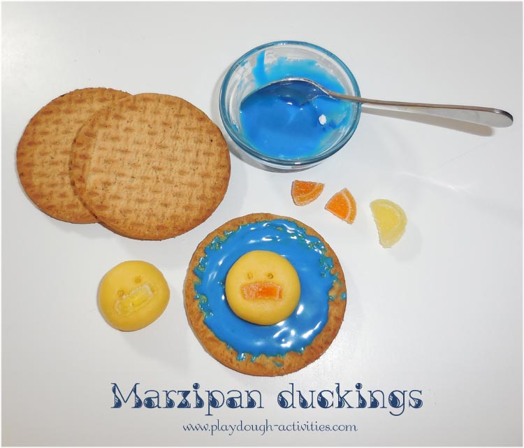 Marzipan dough modelled ducklings on an iced pond biscuit